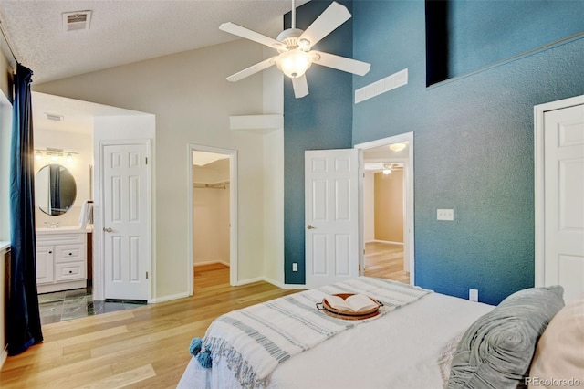 11358 W 85th Pl Unit E, Arvada, CO 80005 - bedroom with high vaulted ceiling, wood finished floors, a closet, a walk in closet, and ensuite bathroom