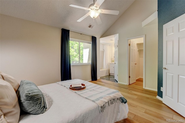 11358 W 85th Pl Unit E, Arvada, CO 80005 - bedroom featuring lofted ceiling, light wood-style floors, a walk in closet, ceiling fan, and a textured ceiling