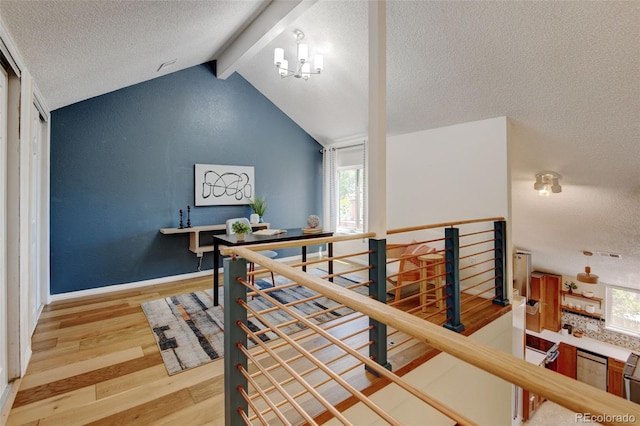 11358 W 85th Pl Unit E, Arvada, CO 80005 - hall featuring an upstairs landing, light wood-type flooring, a textured ceiling, and baseboards