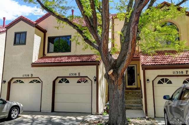 11358 W 85th Pl Unit E, Arvada, CO 80005 - view of front of property with a tiled roof, a garage, and stucco siding