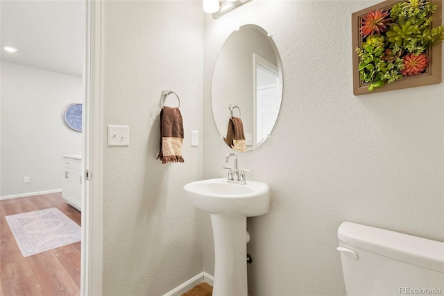 bathroom featuring baseboards, toilet, and wood finished floors