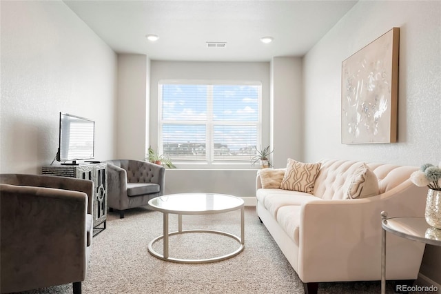 carpeted living area featuring visible vents