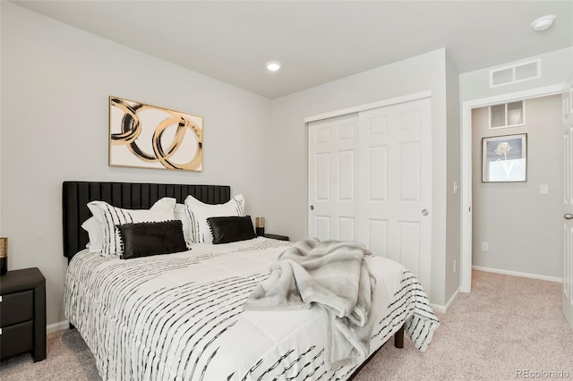 bedroom featuring baseboards, visible vents, a closet, and light colored carpet