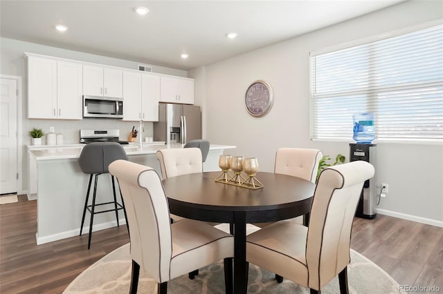 dining room featuring baseboards, recessed lighting, visible vents, and wood finished floors