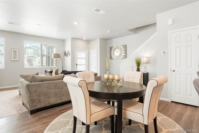 dining area with baseboards, visible vents, and wood finished floors