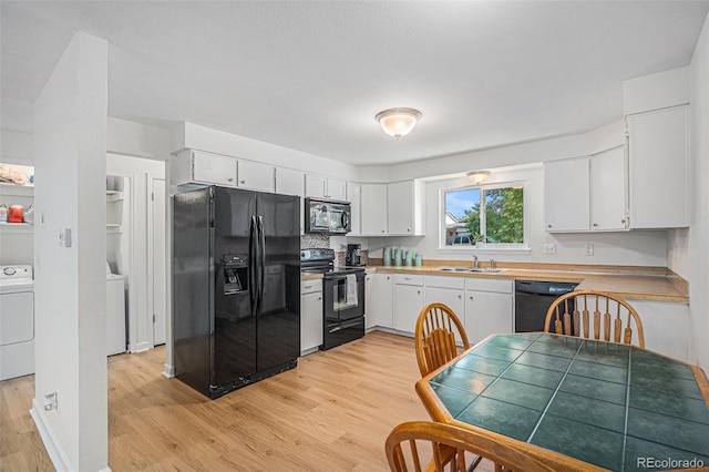 1641 Biscay Cir, Aurora, CO 80011 - kitchen featuring black appliances, light wood-style floors, white cabinetry, washer / dryer, and light countertops