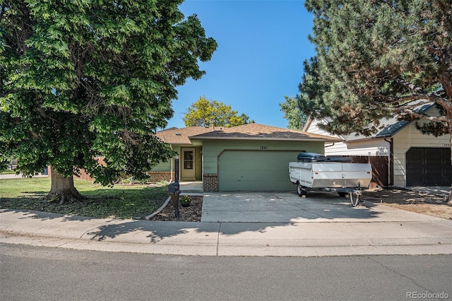 1641 Biscay Cir, Aurora, CO 80011 - view of front facade with an attached garage, brick siding, and driveway
