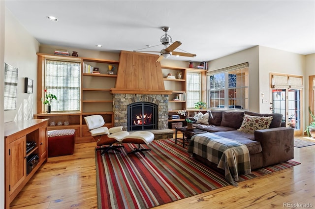 living area featuring recessed lighting, a fireplace, light wood finished floors, and ceiling fan