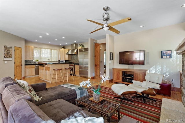 living area with light wood finished floors, recessed lighting, and a ceiling fan