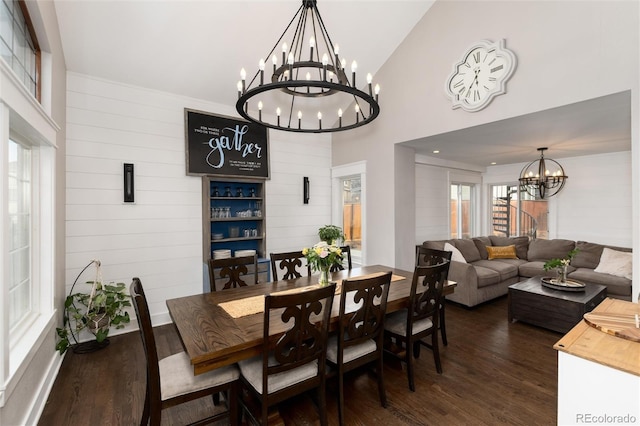 dining room featuring an inviting chandelier, dark wood-style flooring, and high vaulted ceiling