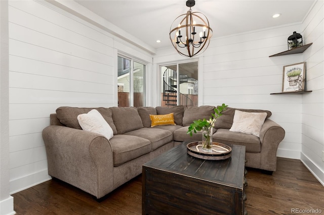 living room featuring recessed lighting, baseboards, an inviting chandelier, and dark wood-style flooring