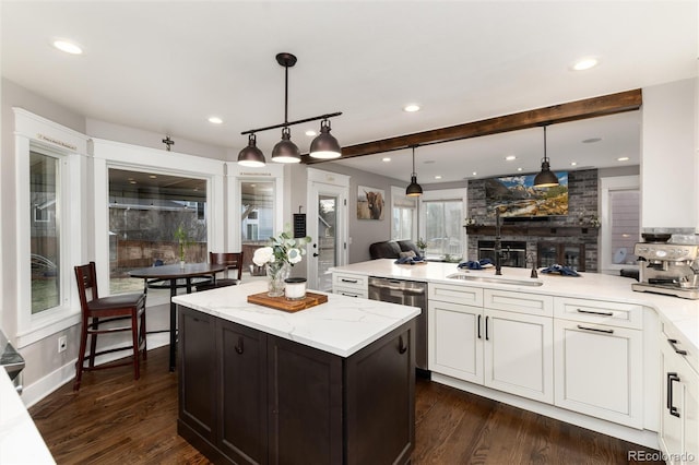 kitchen featuring dishwasher, a peninsula, white cabinets, and light stone counters