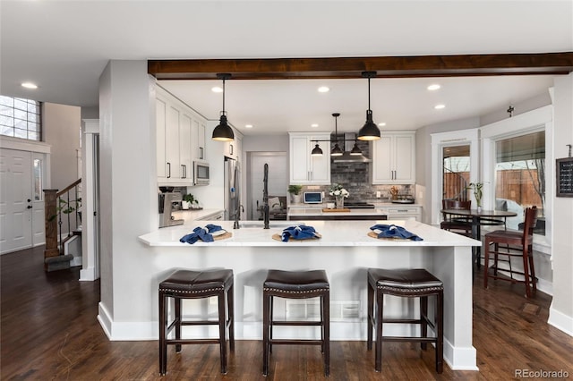 kitchen featuring a peninsula, white cabinets, light countertops, and stainless steel appliances