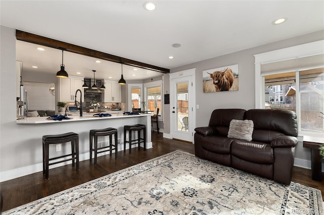 living area with recessed lighting, beamed ceiling, baseboards, and dark wood finished floors