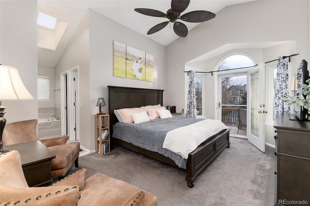 carpeted bedroom with access to exterior, lofted ceiling with skylight, a ceiling fan, and baseboards