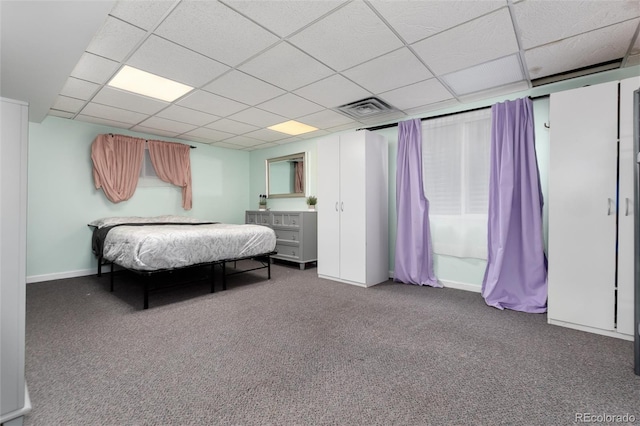 carpeted bedroom featuring visible vents, baseboards, and a drop ceiling