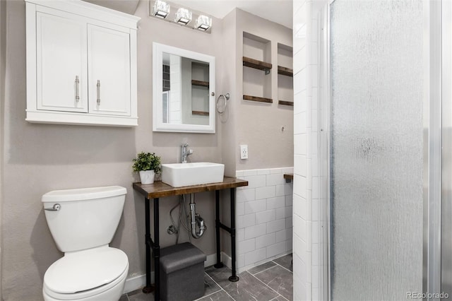 full bathroom featuring a shower stall, toilet, marble finish floor, tile walls, and a sink