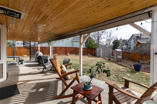 view of patio with an outbuilding, a shed, and a fenced backyard