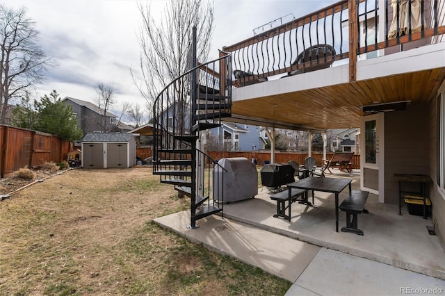 view of yard featuring a storage unit, a fenced backyard, an outdoor structure, stairs, and a patio area