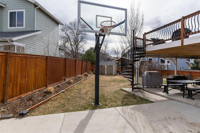 view of yard with a shed, stairs, a fenced backyard, an outdoor structure, and a patio