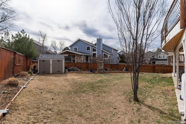 view of yard featuring a fenced backyard, a storage shed, and an outdoor structure