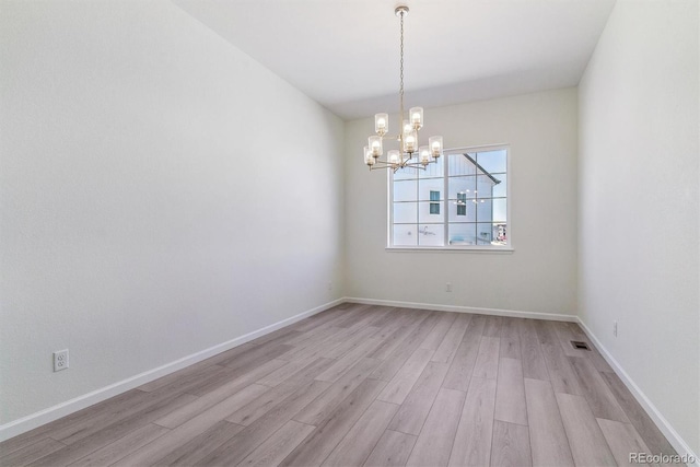 unfurnished room with light hardwood / wood-style flooring and a notable chandelier