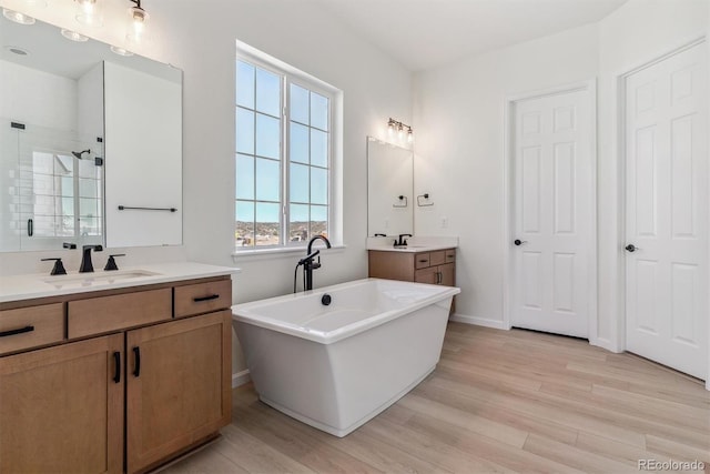 bathroom featuring hardwood / wood-style flooring, vanity, and shower with separate bathtub