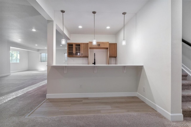 kitchen featuring a kitchen bar, kitchen peninsula, hanging light fixtures, and white refrigerator