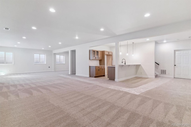 basement featuring light carpet and sink