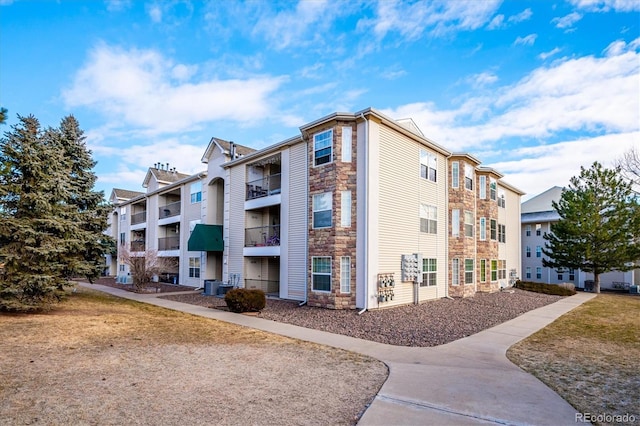 view of property with a residential view and central AC unit