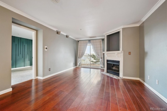 unfurnished living room with ornamental molding, a fireplace, wood finished floors, and visible vents