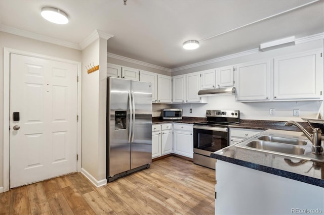 kitchen with under cabinet range hood, a sink, ornamental molding, appliances with stainless steel finishes, and light wood-type flooring