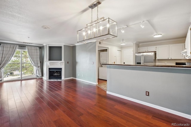 interior space with dark wood-style floors, a fireplace with flush hearth, baseboards, and crown molding