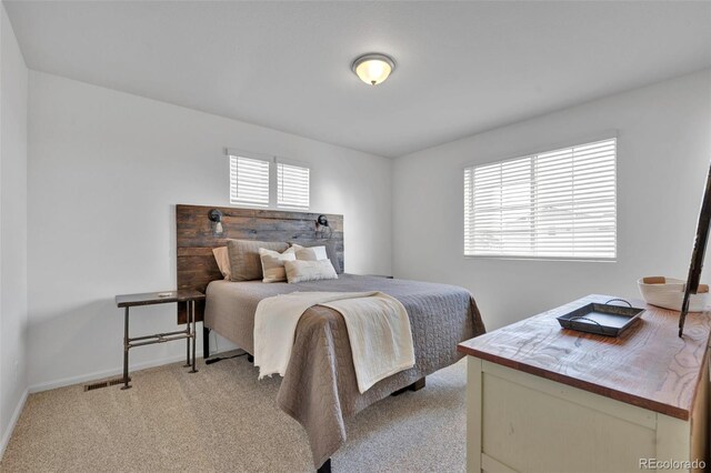 bedroom with baseboards and light colored carpet