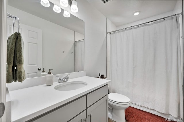 bathroom featuring curtained shower, vanity, and toilet