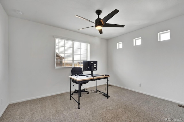 carpeted office with ceiling fan and baseboards