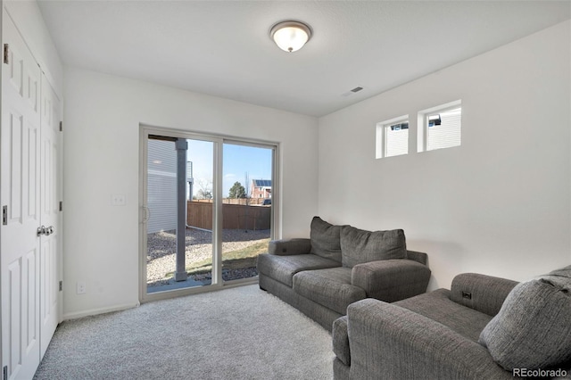 carpeted living area with baseboards and visible vents