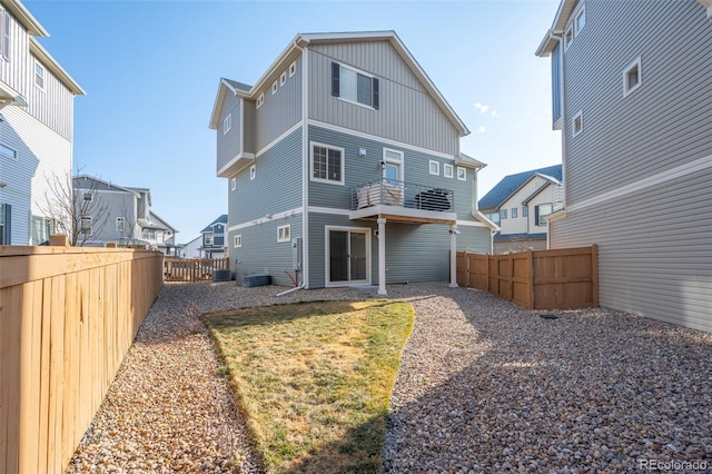 rear view of property with a fenced backyard and central AC