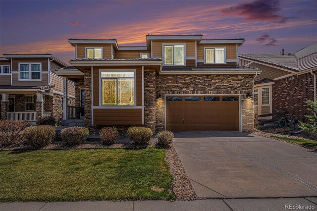 7004 S Addison Ct, Aurora, CO 80016 - view of front of home featuring stone siding, concrete driveway, a garage, and a front yard