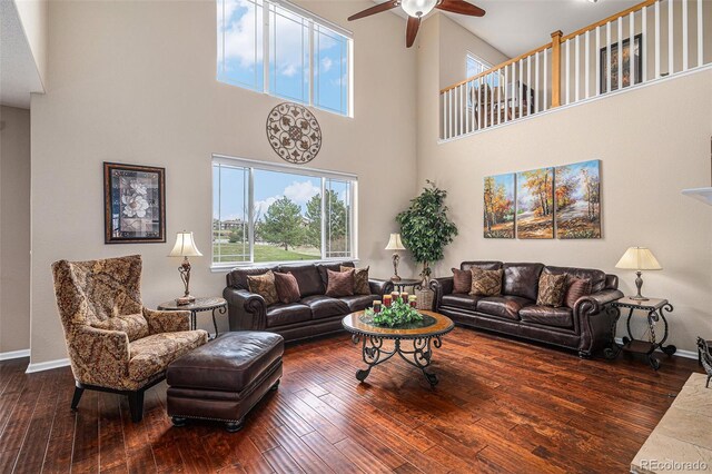 7004 S Addison Ct, Aurora, CO 80016 - living room featuring a ceiling fan, a high ceiling, hardwood / wood-style floors, and baseboards