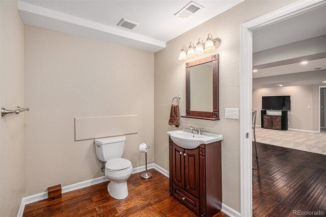7004 S Addison Ct, Aurora, CO 80016 - bathroom featuring wood-type flooring, vanity, toilet, and baseboards