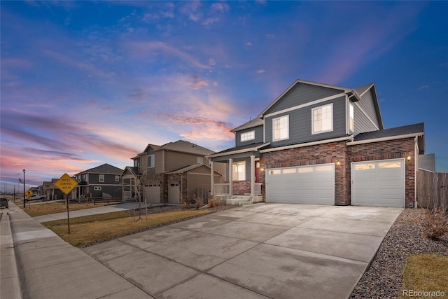 view of front of house featuring concrete driveway, an attached garage, and fence