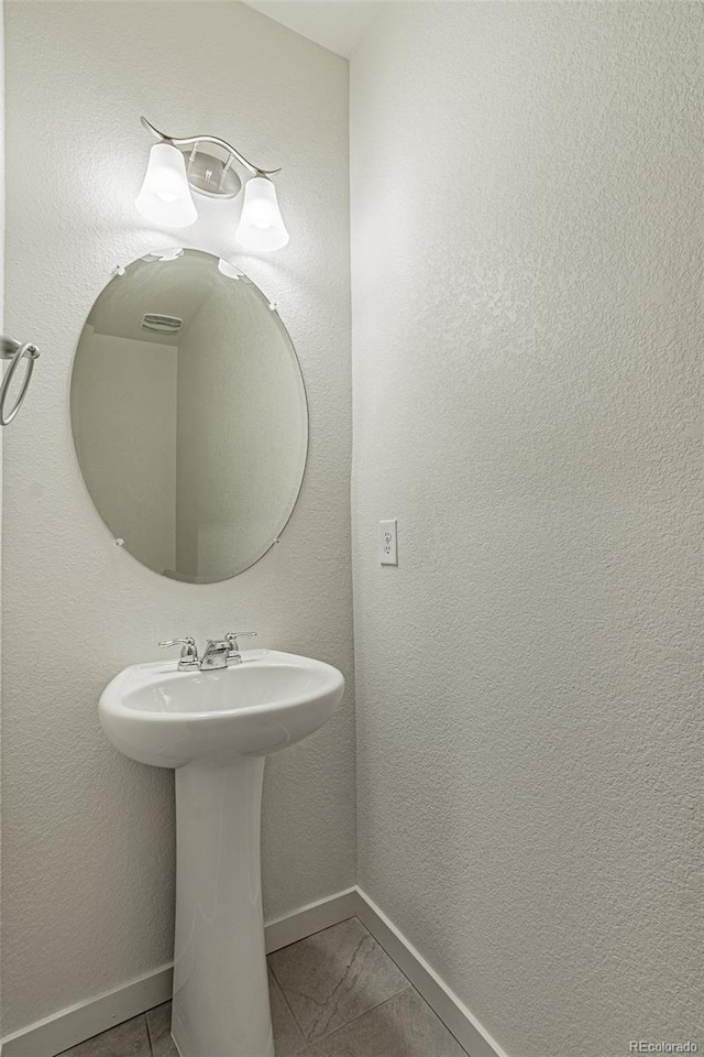 bathroom with baseboards and tile patterned floors