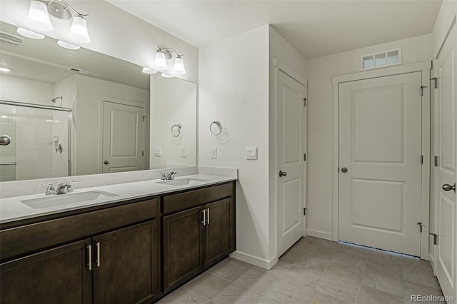 full bath with a sink, double vanity, visible vents, and a tile shower