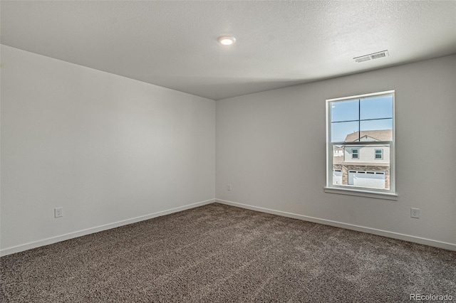 carpeted empty room with baseboards, visible vents, and a textured ceiling
