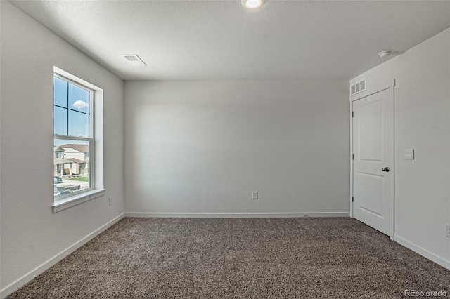 carpeted empty room featuring visible vents and baseboards