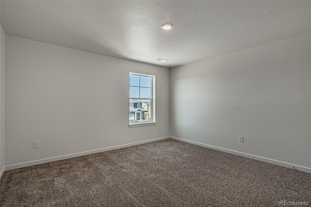 empty room with baseboards, a textured ceiling, and carpet