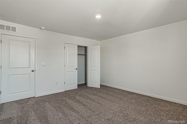 unfurnished bedroom featuring baseboards, a closet, visible vents, and carpet floors