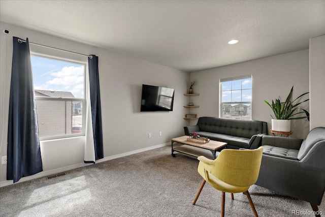 carpeted living room featuring visible vents, baseboards, and recessed lighting