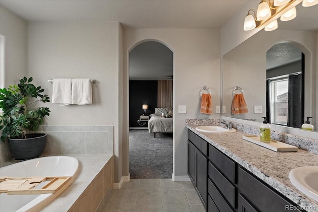 ensuite bathroom featuring a sink, double vanity, ensuite bath, and a garden tub
